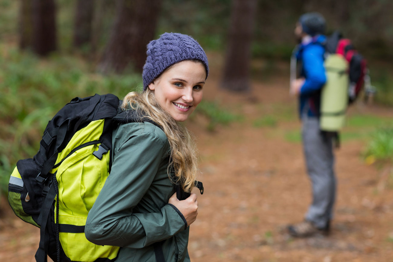 Wanderin steht im Wald und schaut in die Kamera