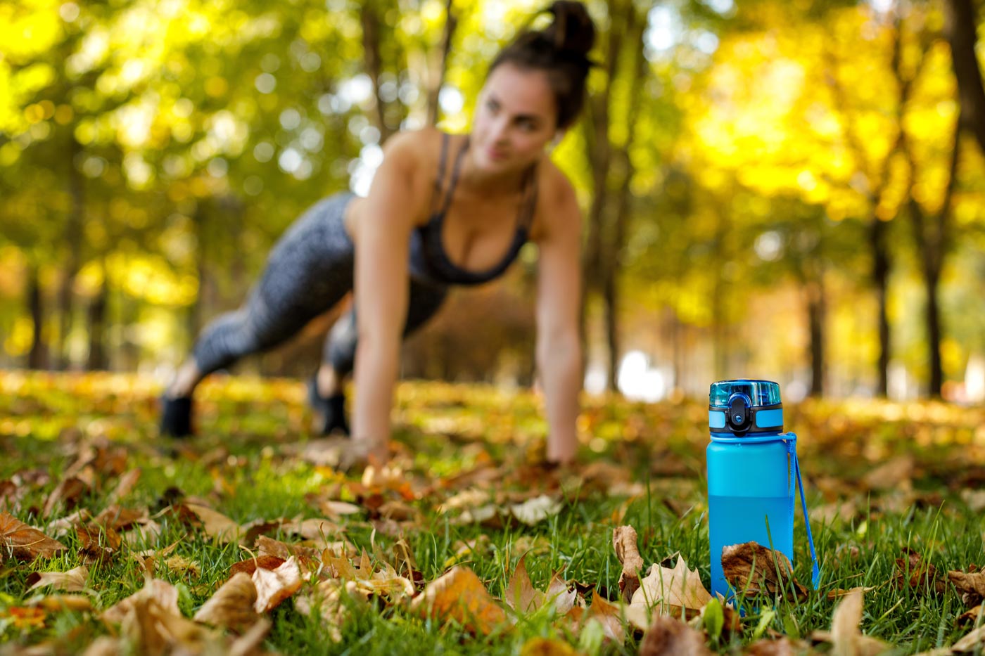 Frau macht Outdoor-Workout mit Liegestütze im Park