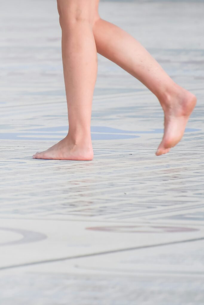 Bare feet walking on a patterned surface.