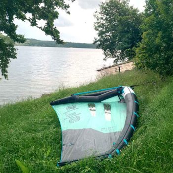 Wing mit einem Boom auf einer Wiese am See